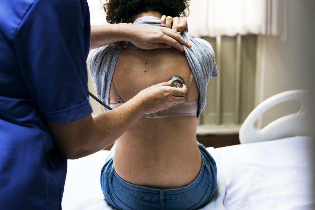 Doctor checking a breathing of a patient